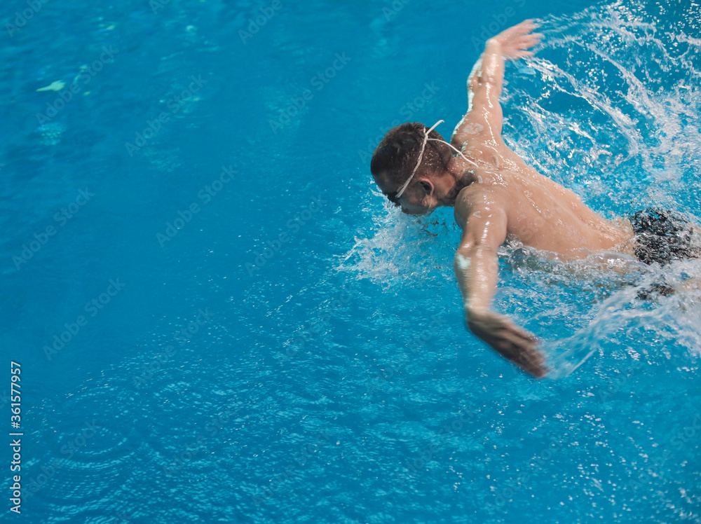 Male swimmer at the swimming pool. Underwater photo. Male swimmer.