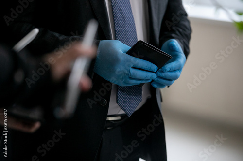 Man in blue medical gloves holds a passport in his hands.