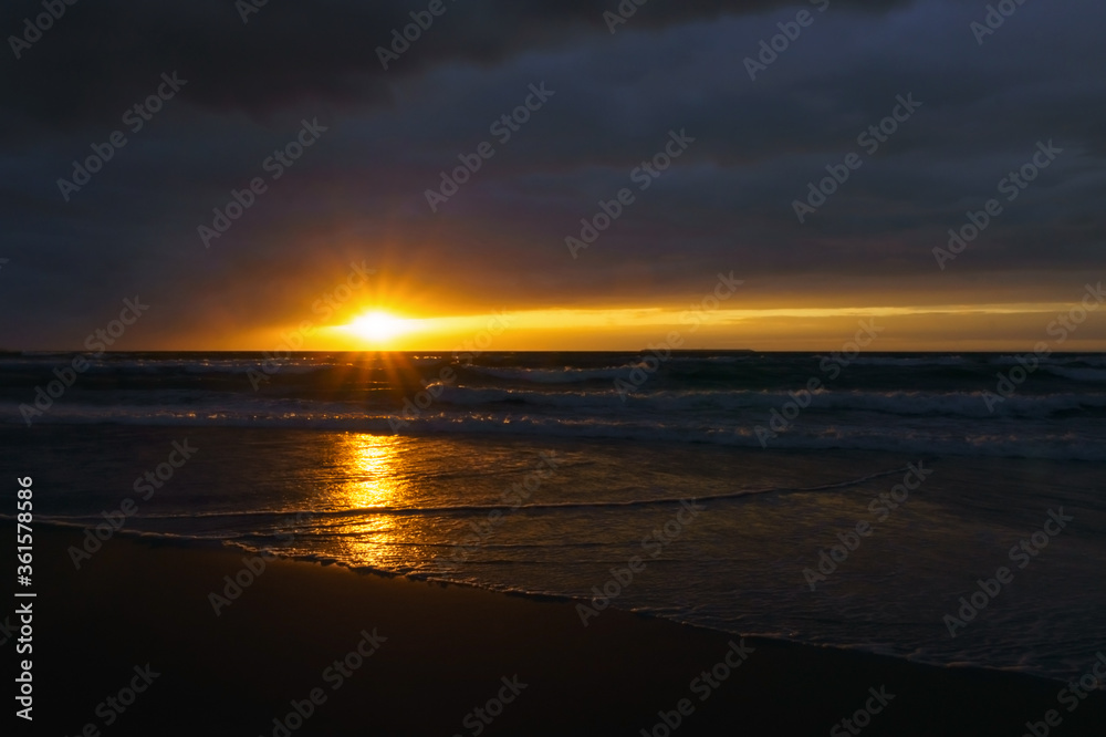 Waves and wind at sunset. Stormy sea at sunset.