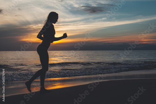 silhouette of a woman running on the beach
