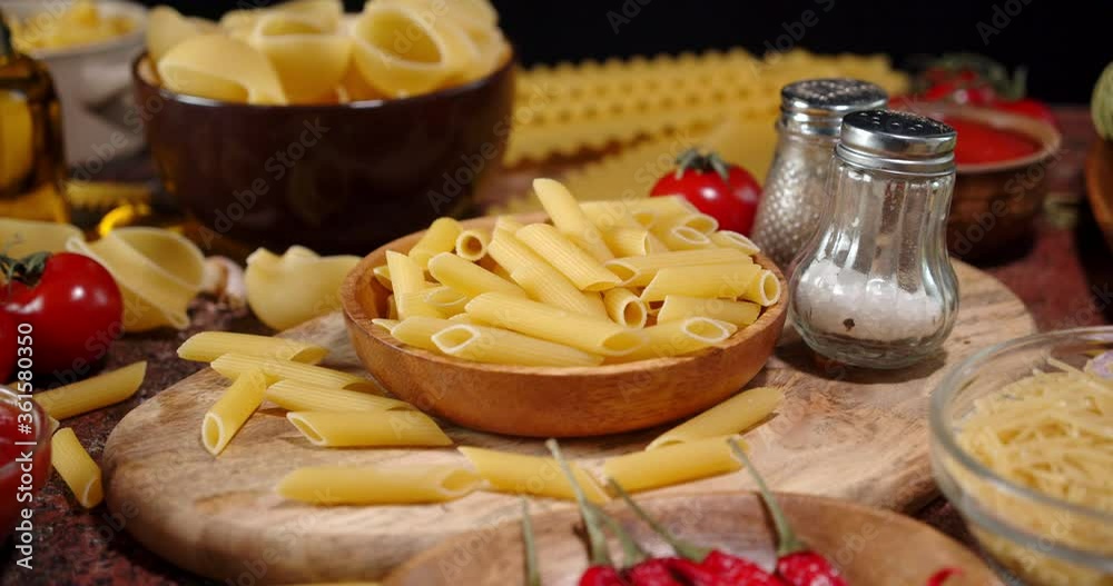 Different pasta dry with spices and tomatoes slowly rotates. Different pasta dry with spices and tomatoes slowly rotates.