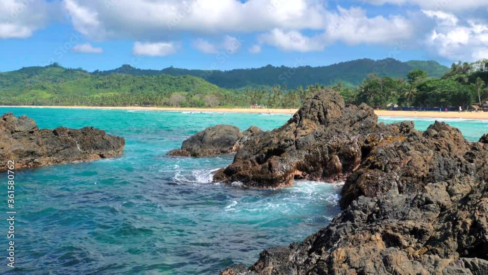 Waves beat against big rocks in the ocean with clear water. Concept of nature. Waves beat against big rocks in the ocean with clear water. Concept of nature.