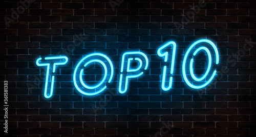 Top 10 neon light text on empty red brick wall banner. Bright neon sign of top ten list winners at night. Design template of modern signboard or advertising.