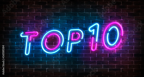 Top 10 neon blue and pink light text on empty red brick wall banner. Bright sign of top ten list winners at night. Design template of modern signboard or advertising.