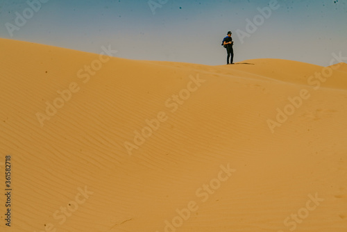 A young tourist standing on the desert at Merzouga  Morocco