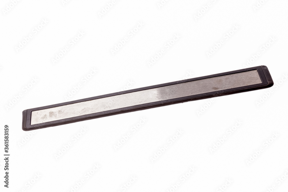 Decorative overlay is applied to black auto pass with metal element on white isolated background in photo studio for sale at an auto-analysis or for replacement during repair in a car service center.