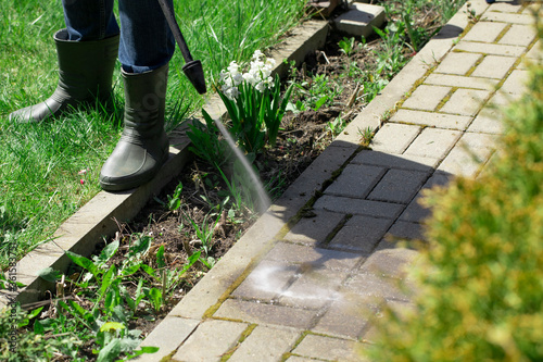 high-pressure washer cleans concrete stones of garden line country house. Spring cleaning concept. Cleaning garden area. natural resources saving concept Dangerous works