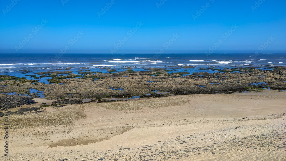Sea waves breaking on rocks in Esposende, Portugal. Sea, beach boulders, pebble shore and waves in the morning. Sea waves breaking on rocks in Esposende, Portugal. Sea, beach boulders, pebble shore and waves in the morning.