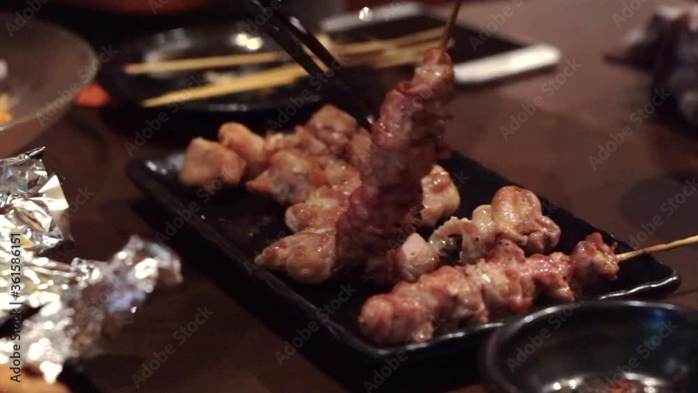 Eating Japanese izakaya yakitori grill chicken unskewered to share Eating Japanese izakaya yakitori grill chicken unskewered to share