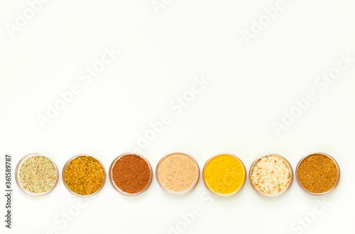 Condiments and herbs on white background. Flat lay. Top view. 