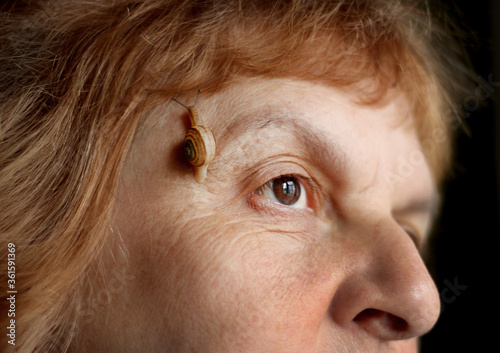 Portrait of a woman with a snail on her face