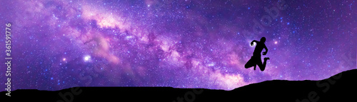 Amazing Panorama blue night sky milky way .Universe filled with stars, nebula and galaxy with noise and grain.Photo by long exposure and select white balance.Dark night sky.Silhouette of man jumping .