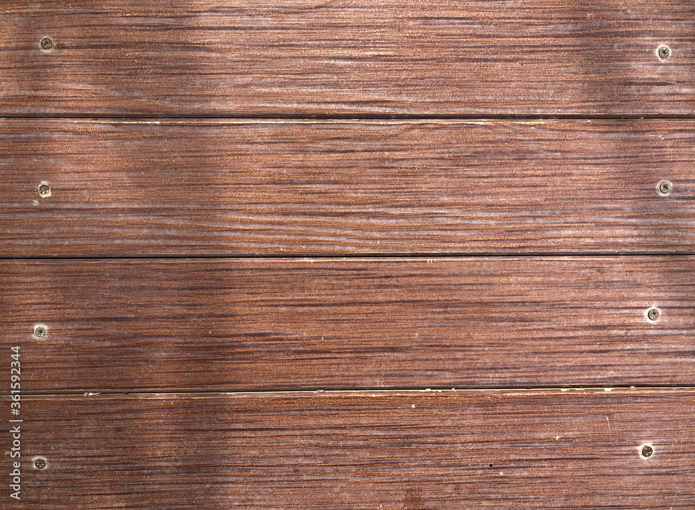 Fototapeta premium Abstract brown wooden surface with screws attached to the background, brown wood texture.