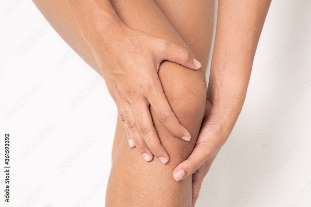 Pain in woman knee. Female holding hands on spot pain , Isolated on white background Pain in woman knee. Female holding hands on spot pain , Isolated on white background