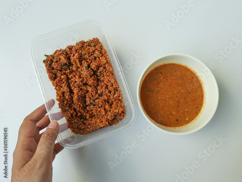 Sambel pecel or peanut sauce from Indonesia, for Indonesian salad. Comparison before and after diluted. Before diluted sauce is mashed solid peanut mixed with spices. photo