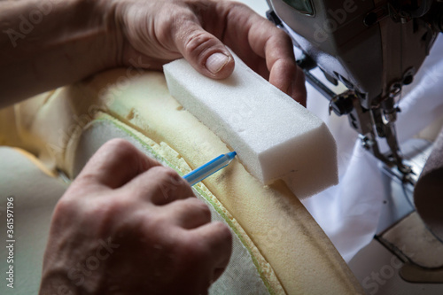 A person repairs the foam seat of a car.