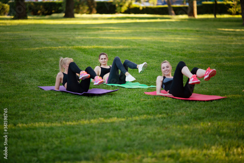 girls doing aerobics exercises together outdoors in a park