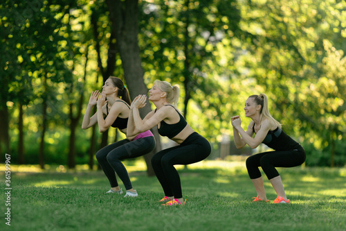 girls doing aerobics exercises together outdoors in a park