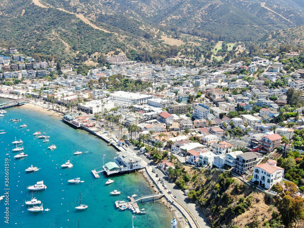 Aerial view of Avalon harbor in Santa Catalina Island with sailboats, fishing boats and yachts moored in calm bay, famous tourist attraction in Southern California, USA