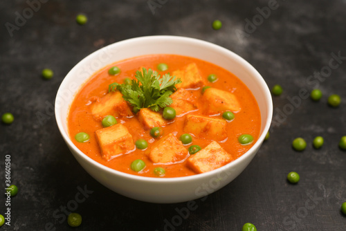 Tapety artystyczne Matar Paneer curry recipe made using cottage cheese, green peas, served in bowl. selective focus Delhi, Rajasthan India. Top view Indian veg curry on dark background. side dish of Roti, Chapati, naan
