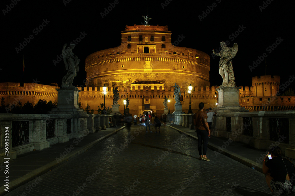 Sant'Angelo castel in Rome at night, seen from the Ponte dell'Angelo. Streetlights on black sky.