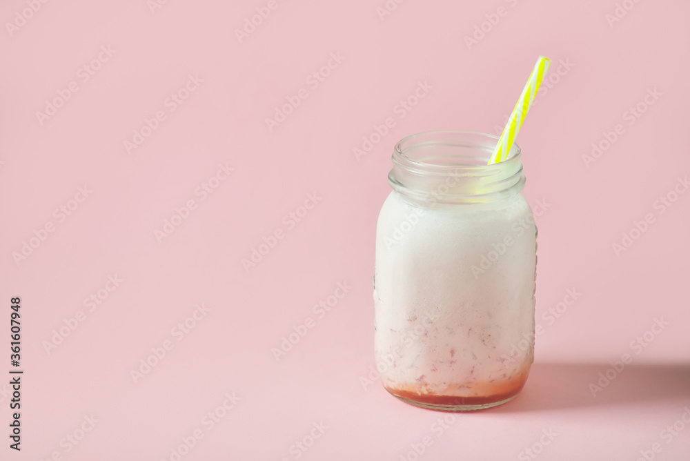 milk strawberry smoothie in jar with yellow straws on pink background milk strawberry smoothie in jar with yellow straws on pink background