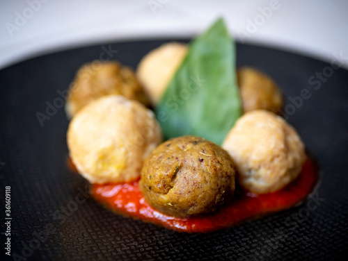 Vegan legume meatballs with fresh tomato sauce and basil leafe