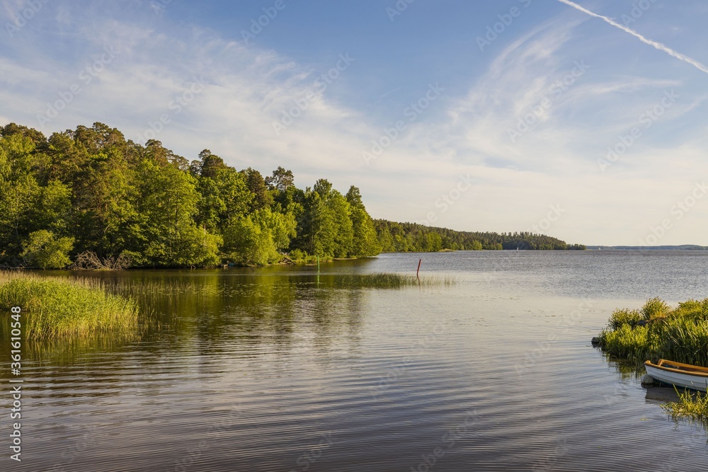 Beautiful lake view with boats on blue sky with white clouds background. Beautiful summer nature backgrounds. Sweden, Europe. Beautiful lake view with boats on blue sky with white clouds background. Beautiful summer nature backgrounds. Sweden, Europe.