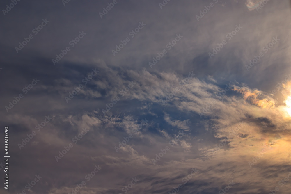 patch of blue sky and part of the sun covered by a thin layer of transparent clouds.