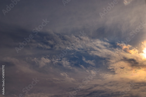 patch of blue sky and part of the sun covered by a thin layer of transparent clouds. © conpuli