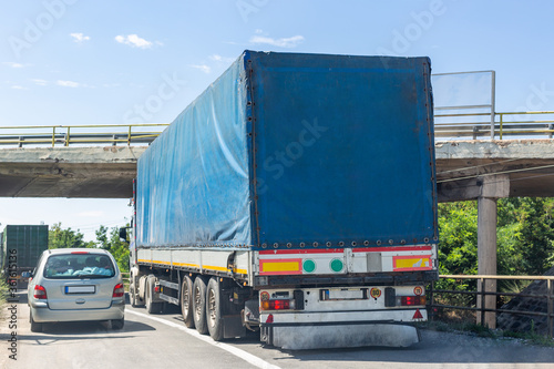 Blue track trying to pass under the elevated road. Truck colliding with bridge