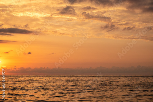 Sunset at sea. Red, yellow sky. Blue clouds. The sun falls into the water. Evening. Black Sea. Georgia.