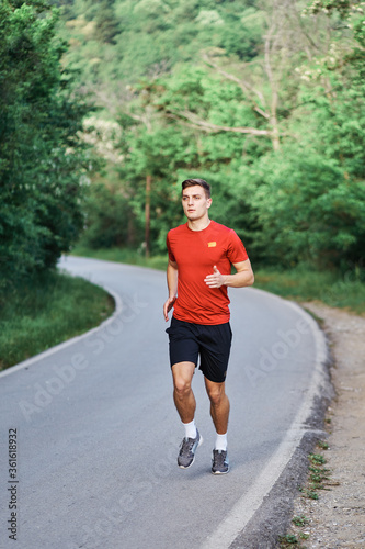 Young man running alone on an empty road © Vojkan M