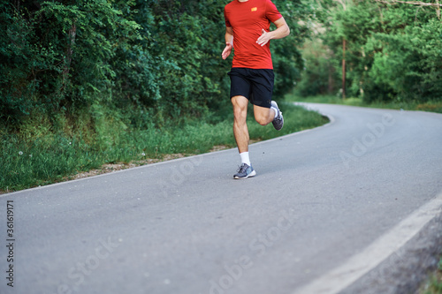 Young man running alone on an empty road