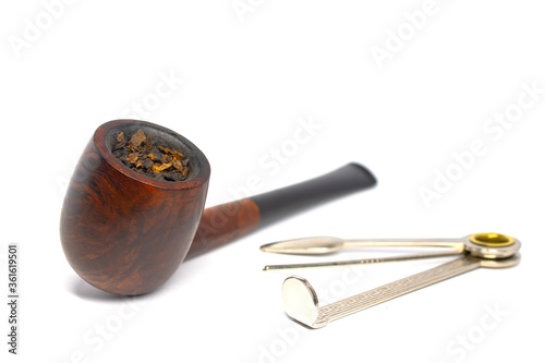Smoking briar pipe with czech tool on a white background