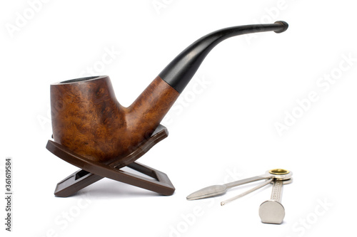 Smoking briar pipe with czech tool on a white background