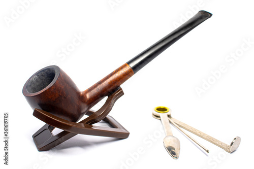 Smoking briar pipe with a czech tool on a white background