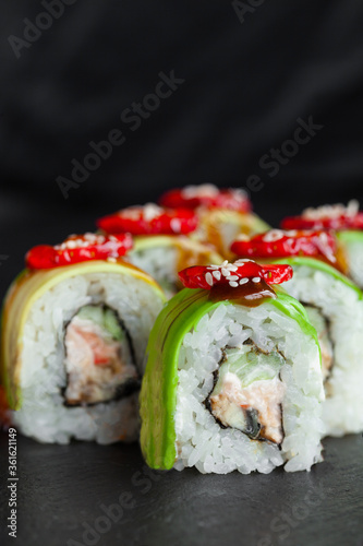 Portion of fresh sushi roll with avocado, strawberry, cheese