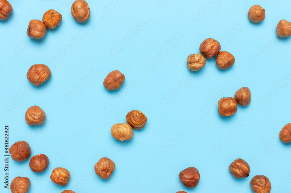 Creative food layout. Hazelnuts on blue background top view copy space. Concept of food, healthy nutrition, nut, healthy fats. Hazelnut Flat lay. Walnut pattern. Organic healthy vegan snack Creative food layout. Hazelnuts on blue background top view copy space. Concept of food, healthy nutrition, nut, healthy fats. Hazelnut Flat lay. Walnut pattern. Organic healthy vegan snack