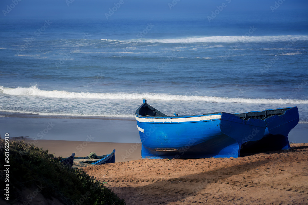 blue boats of fishermen on the shore against the background of the Atlantic ocean blue boats of fishermen on the shore against the background of the Atlantic ocean