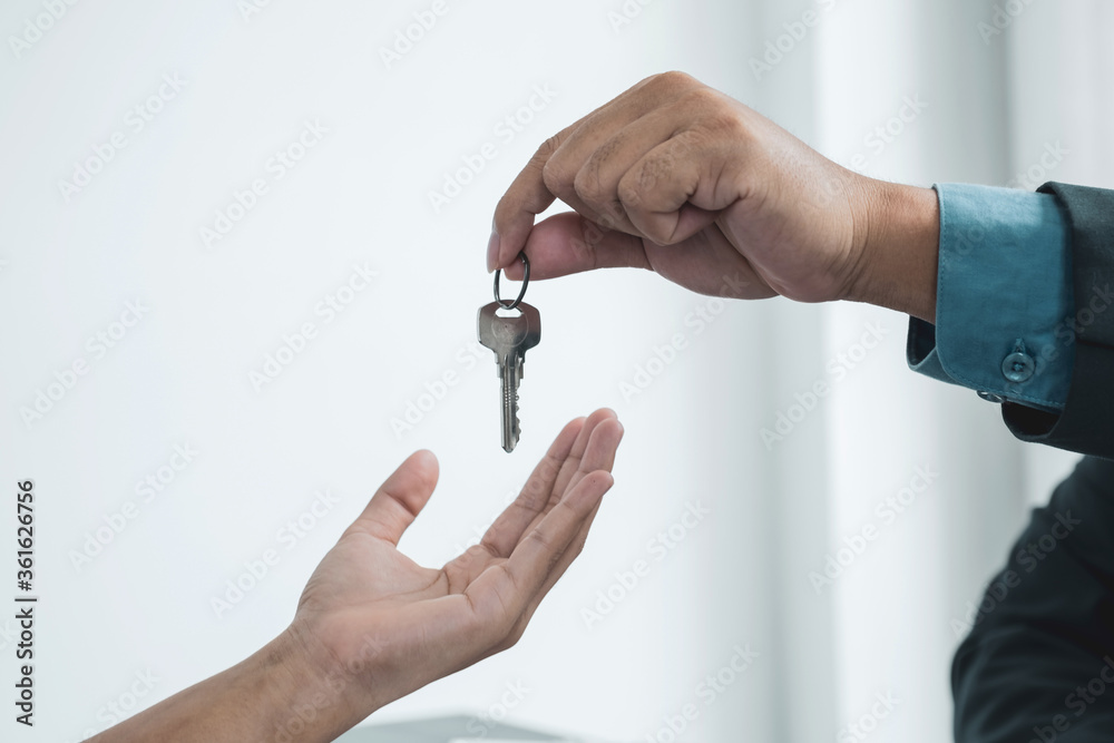 Hand a real estate agent, hold the keys, and explain the business contract, rent, buy, mortgage, loan, or home insurance Hand a real estate agent, hold the keys, and explain the business contract, rent, buy, mortgage, loan, or home insurance