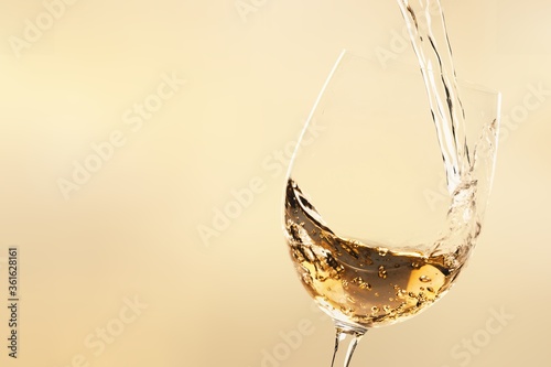 White wine being poured in wineglass photo