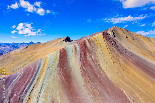 Aerial landscape of The Red Valley at Rainbow Mountain (Vinicunca Valley). Apu Ausangate is behind. All rocks, mountains and sand is invaded by red colors. Cusco Region, Peru