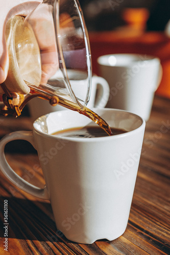 Foto The coffee is alternatively made using a paper filter and a kemex is poured from the flask into a mug