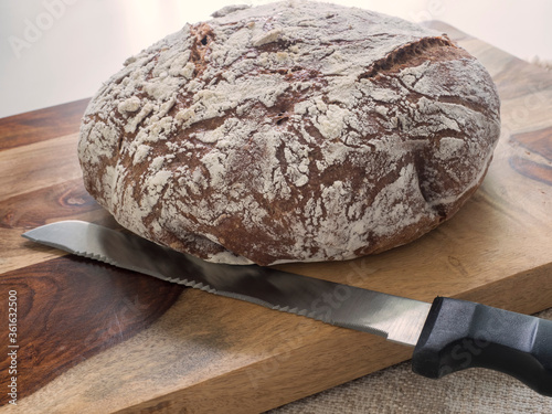 Tableau sur toile Pumpernickel Bread Loaf Whole on Bread Board with Knife