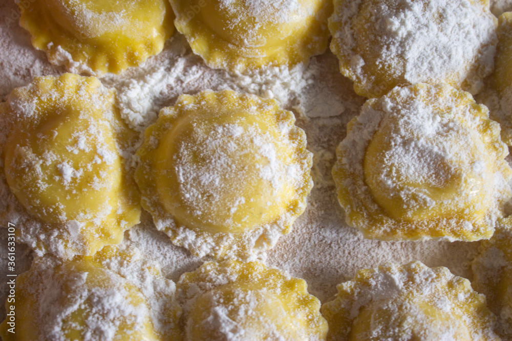 Top view homemade Ravioli / Tortellini /dumplings on floured wood board.Healthy italian food macro. Top view homemade Ravioli / Tortellini /dumplings on floured wood board.Healthy italian food macro.