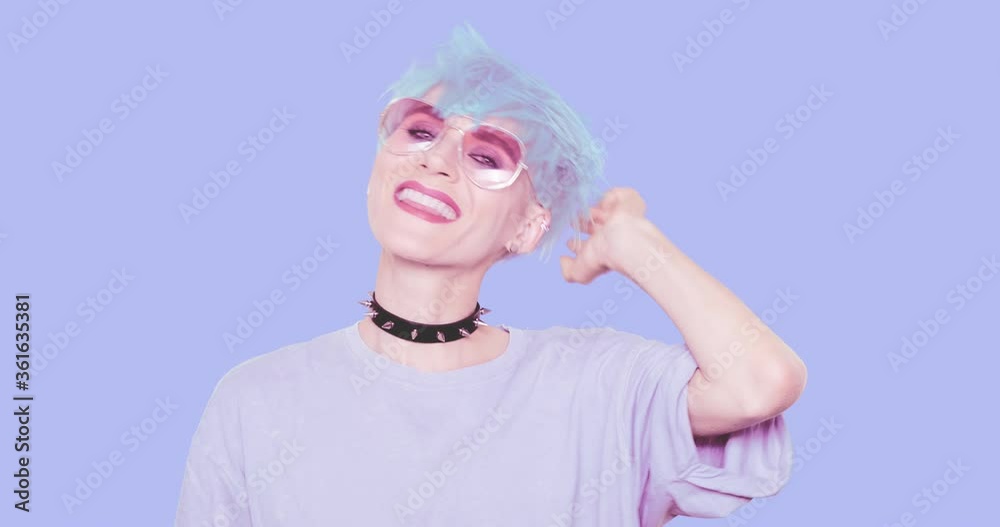 Fashion Sexy Girl with blue hair, stylish casual look posing in studio against blue background. Urban stylish and accessories concept Fashion Sexy Girl with blue hair, stylish casual look posing in studio against blue background. Urban stylish and accessories concept