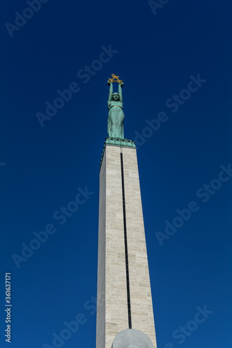 Copper figure of Liberty at the top of the Freedom Monument in Riga, Latvia. It is a 9 meters woman lifting three gilded stars, symbolizing the districts of Latvia: Vidzeme, Latgale and Courland.