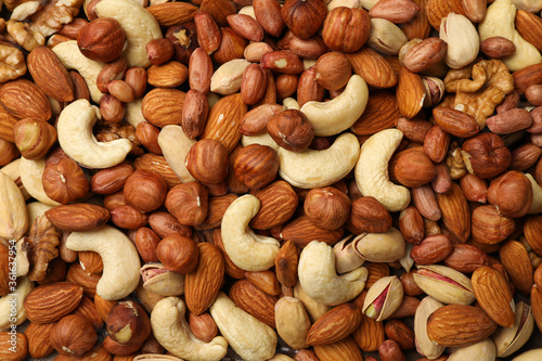 Different tasty nuts on whole background. Vitamin food