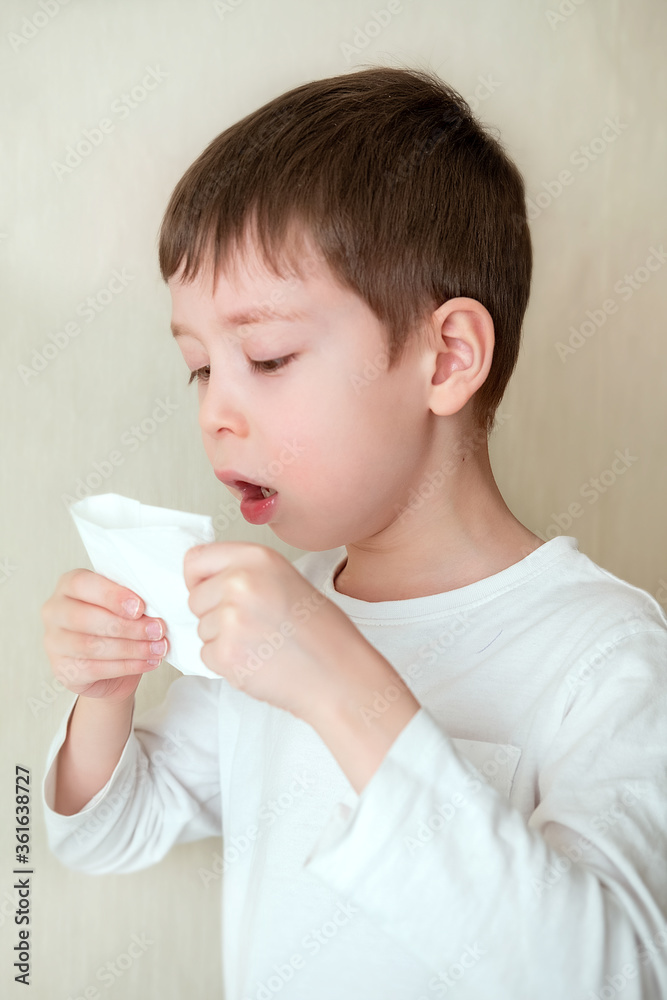 baby coughs, covering mouth with tissue. sick boy on a white background baby coughs, covering mouth with tissue. sick boy on a white background